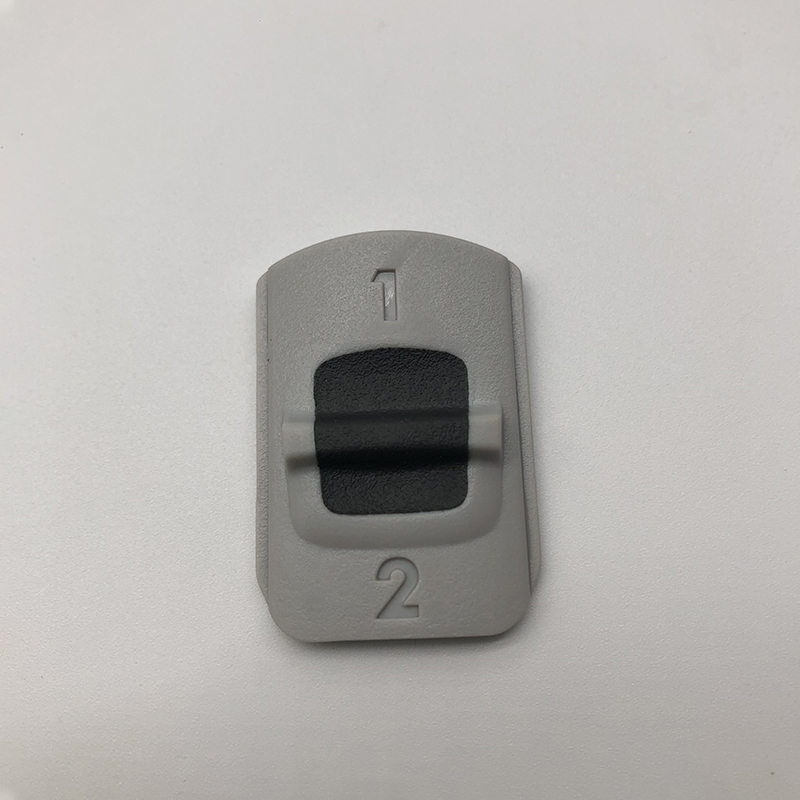 Two-color buttons with plastic overmold